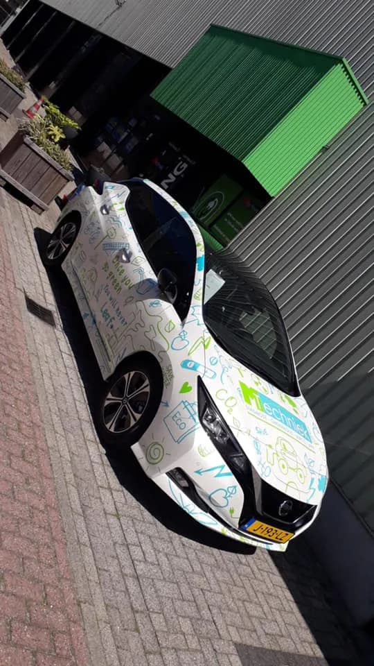 Gewrapte Nissan Leaf elektrische auto geparkeerd voor de garage van MTechniek Alkmaar.